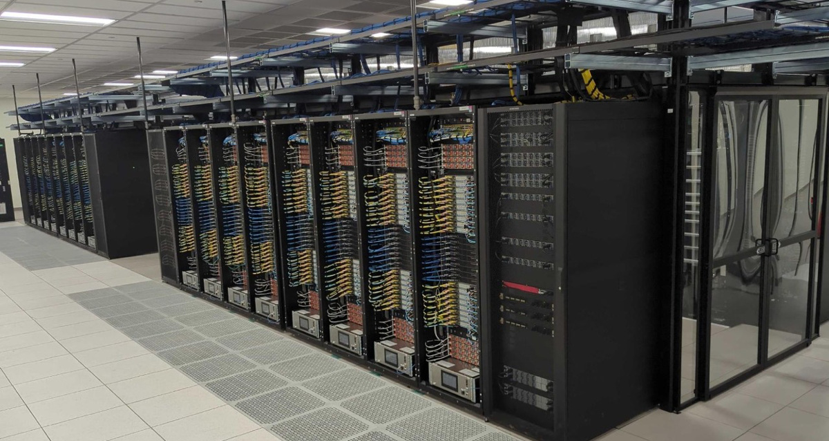 Rangée de baies serveur densément câblées dans un datacenter, avec des unités de calcul GPU visibles