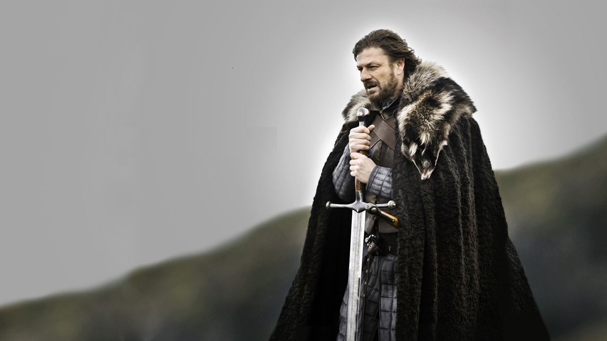 Ned Stark de Game of Thrones, en cape de fourrure, les mains posées sur le pommeau de son épée (meme Winter is coming)
