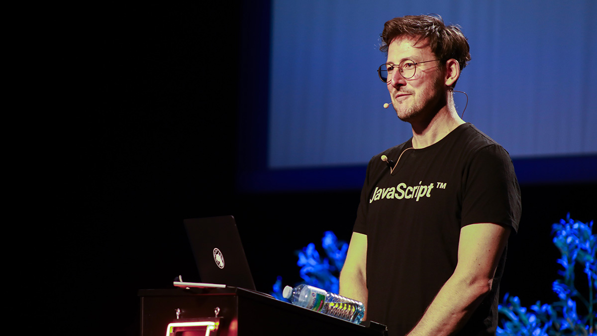 Ryan Dahl, créateur de Deno, en conférence avec son t-shirt JavaScript