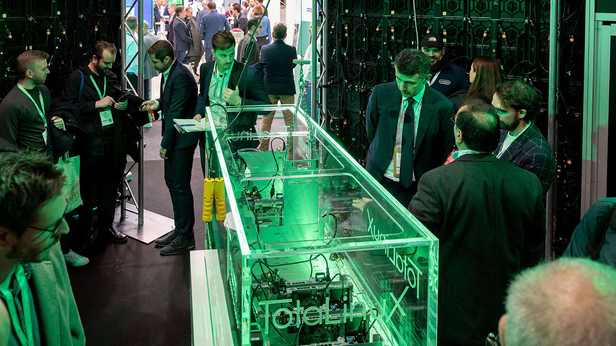 Visiteurs autour d'un serveur TotaLinuX vitré éclairé en vert à Tech Show Paris